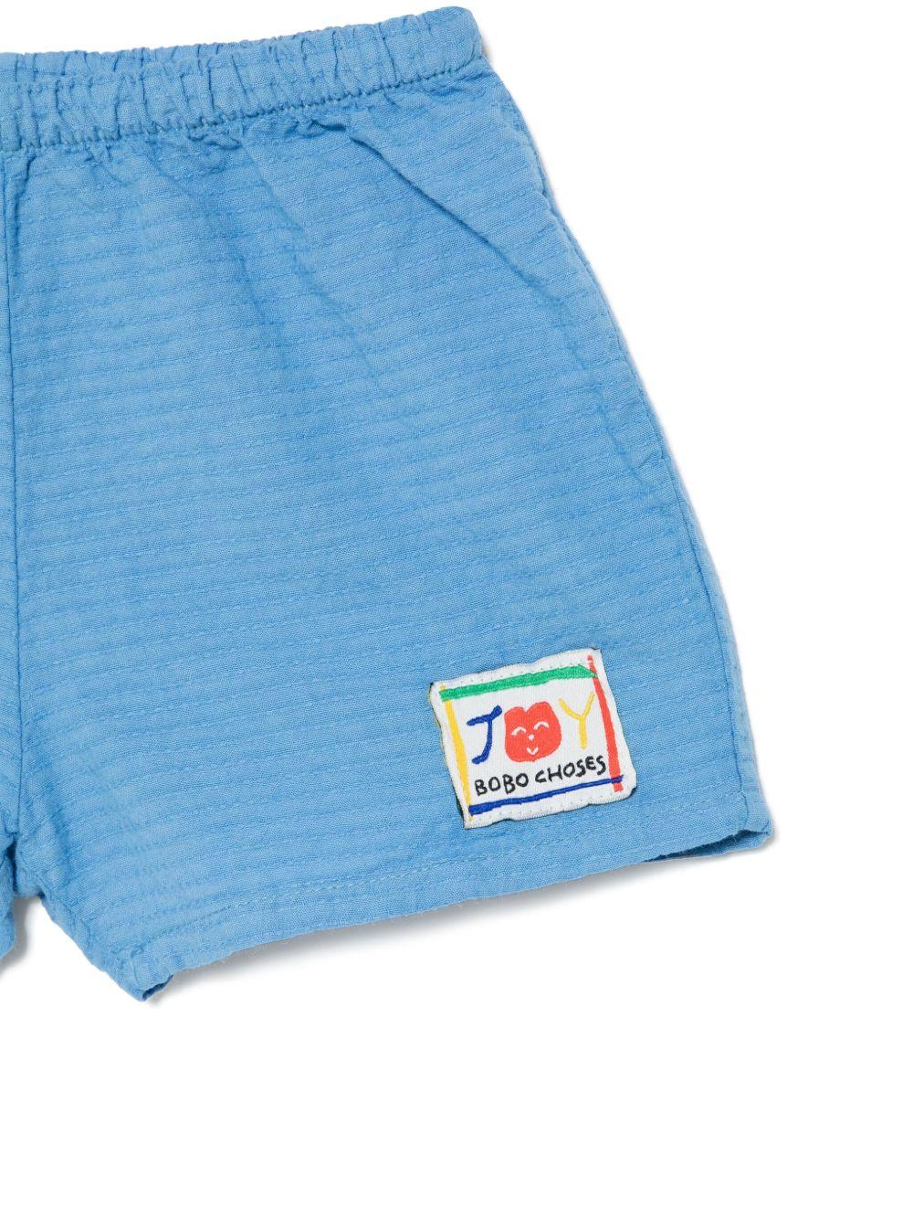 Shorts per neonato Bobo Choses Smilling azzurro con applicazione frontale con logo B125AB044 421 BOBO CHOSES