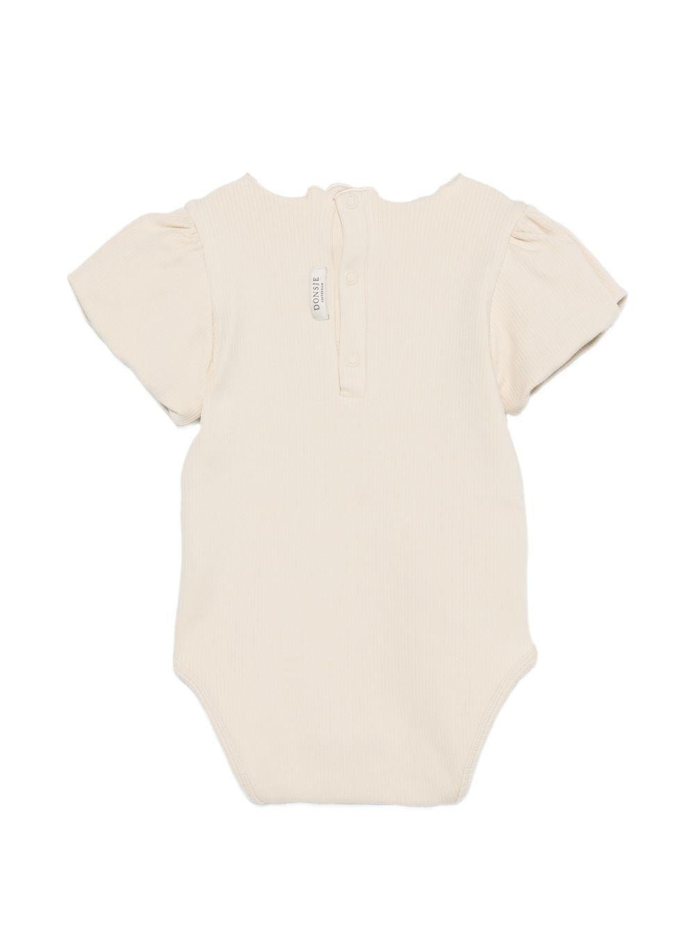Tutina per neonata Donsje beige con dettaglio fiore sul davanti - Rubino Kids