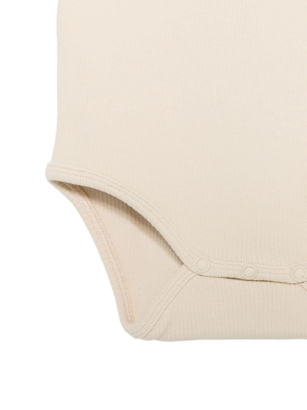 Tutina per neonata Donsje beige con dettaglio fiore sul davanti - Rubino Kids