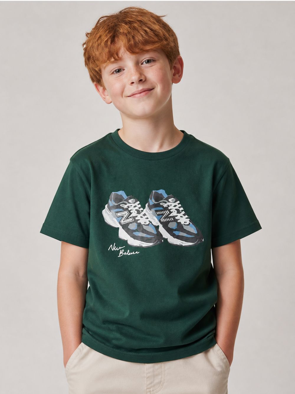 T-shirt per bambino New Balance Kids verde con stampa scarpe sul davanti YT62A1UP NOG NEW BALANCE KIDS 