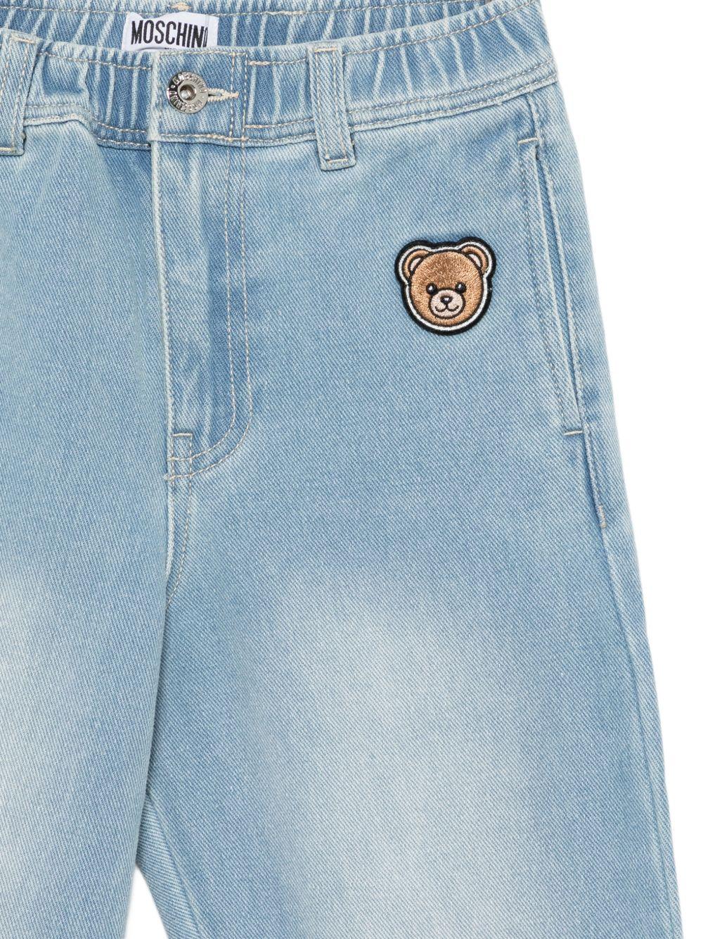 Jeans per bambino Moschino Kids azzurri con decorazioni in rilievo HUP08XL0E37 41100 MOSCHINO KIDS 